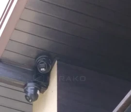 Dwie kamery Hikvision 4K zamontowane pod dachem, z przewodami poprowadzonymi w brązowych listwach dopasowanych do podbitki. Dwie kamery Hikvision 4K zamontowane pod dachem, z przewodami poprowadzonymi w brązowych listwach dopasowanych do podbitki.