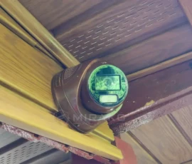 Brązowa kamera IP Hikvision 4 MP zamontowana pod okapem domku letniskowego