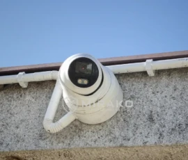 Zbliżenie kamery Hikvision zamontowanej na puszce montażowej na elewacji