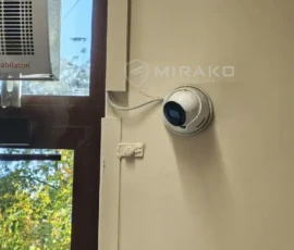 Kamera monitoringu na ścianie przy drzwiach wejściowych sklepu